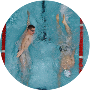 Two community members using the campus pool to swim laps.